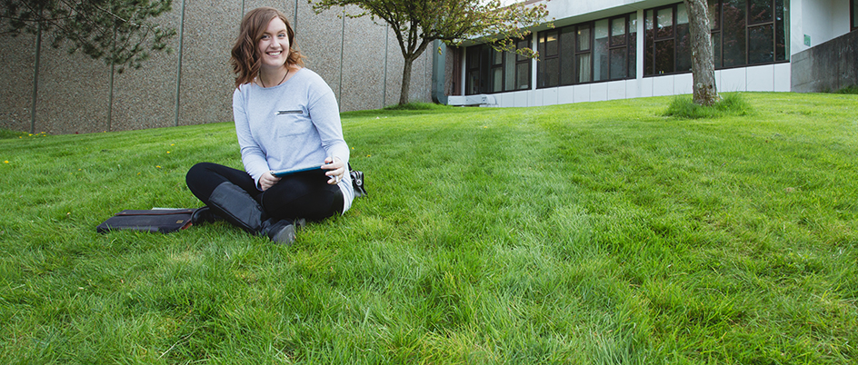 Student sitting on the grass on campus