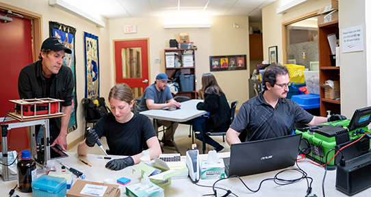 Bruce Wallace, associate professor of social work and scientist with UVic’s Canadian Institute for Substance Use Research, looks on as chemistry co-op student Ashley Larnder (centre) and biochemist Ian Garber analyze a client’s drug sample at AIDS Vancouver Island (AVI) in Victoria—one of the pilot sites for the UVic drug checking project.