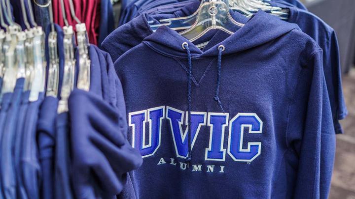 Blue UVic alumni sweaters hanging on rack