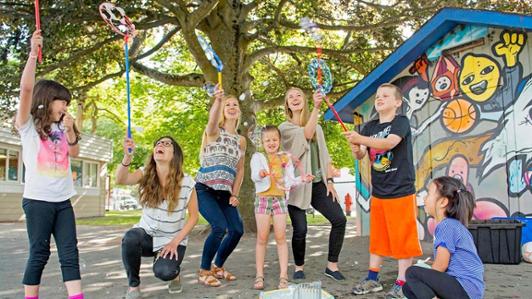 group of adults and youth playing with bubbles