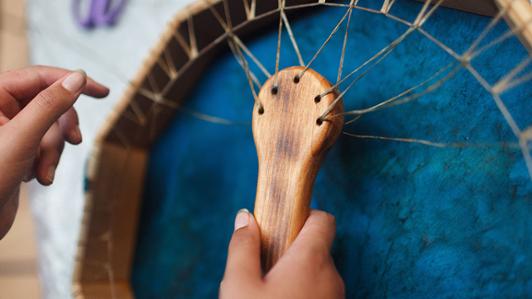 Up close shot of hands working on a drum weave.