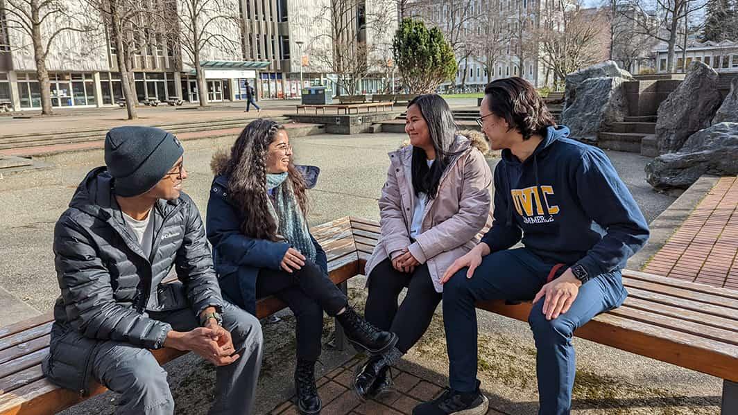 Four international students seated in the quad at UVic in the fall