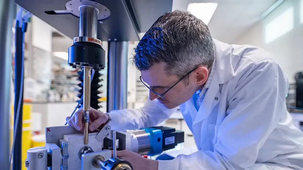 Josh Giles, Mechanical Engineering uses a machine in a lab.