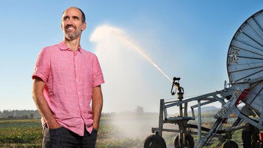 Photo of UVic's Professor Tom Gleeson in an agricultural field being irrigated