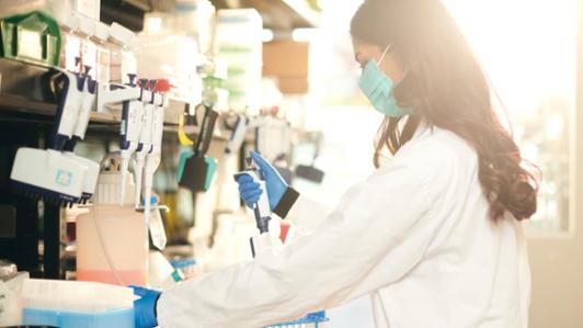 Photo of a female UVic researcher working with samples in a lab