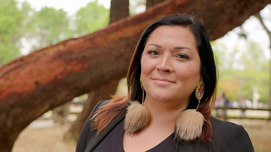 Profile image of Dr. Heather Igliorte with a green landscape on campus
