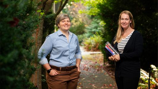 Profile photo of Dr. Theone Paterson and Brianna Turner in a forested area on campus