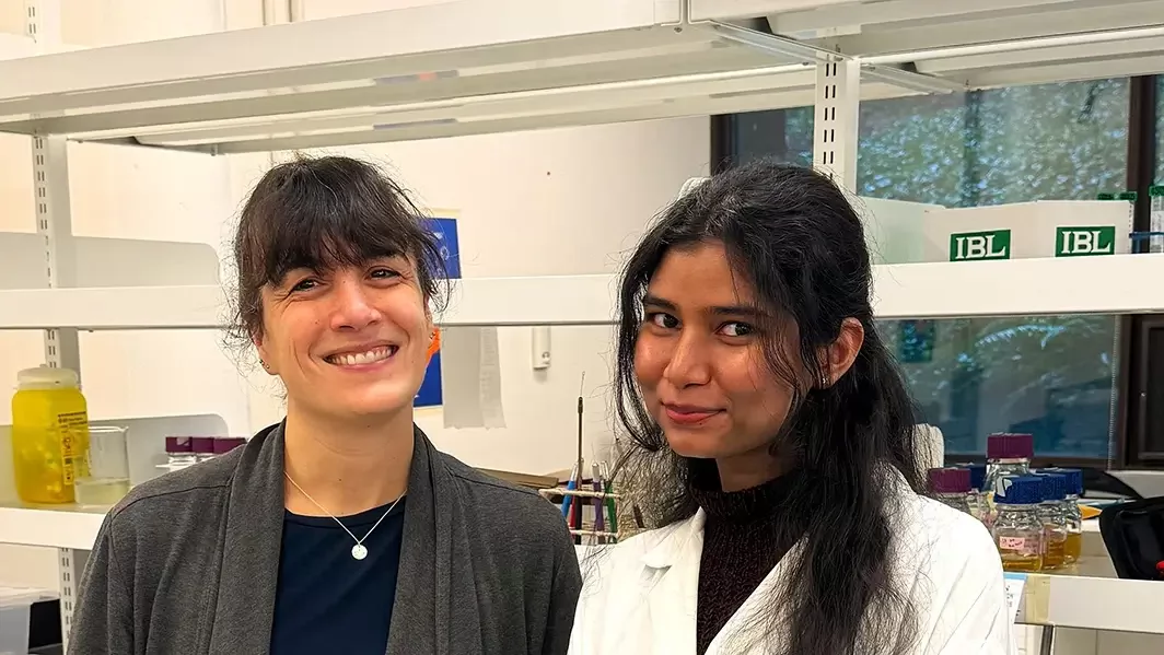 Nicole Templeman and Faria Athar stand together smiling in the lab at UVic.