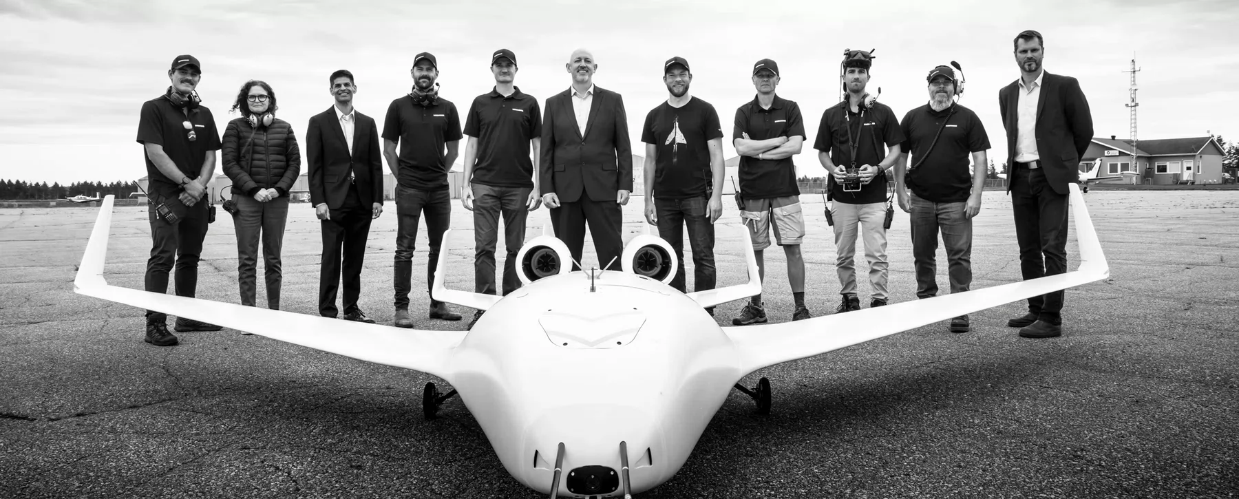 A crew of engineers stand behind a plane