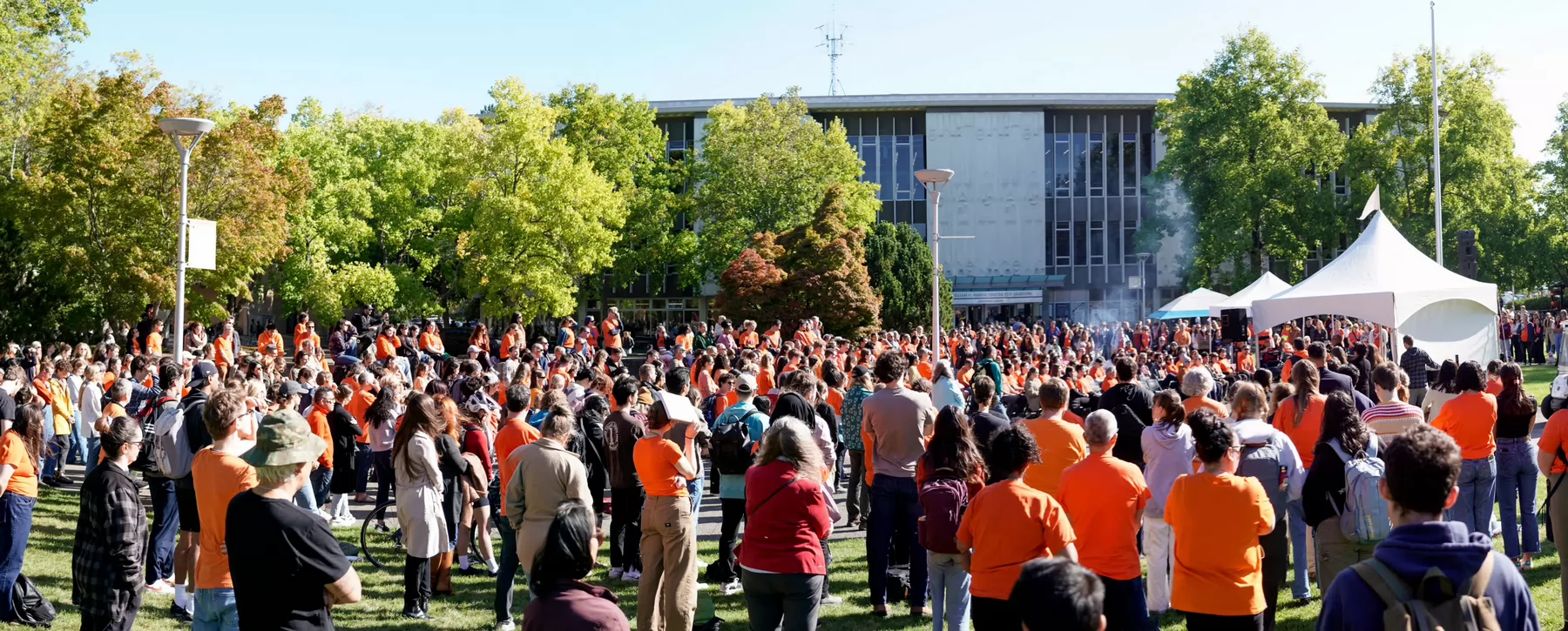 A large crowd of people attend the Orange Shirt Day ceremony on campus.