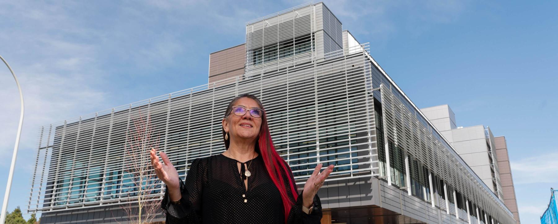 VPI Robina Thomas stands in front of new student residence building one.