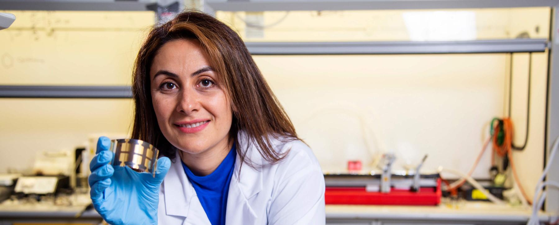 Sahar Sam holds a solar cell.