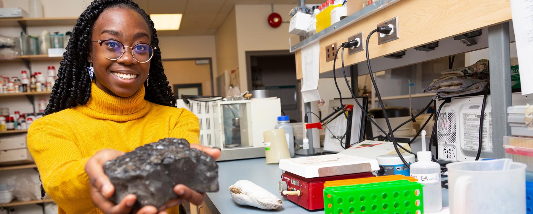 researcher holding rock in lab