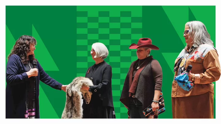 Four women stand together. One is presented with an animal pelt in recognition for her work.