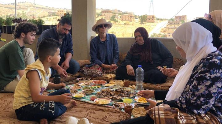 The Al-Khawaldahs share a traditional Bedouin breakfast with Vibert, Azzam and members of the film crew.