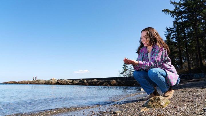 Second-year undergraduate science student Quinn Bitz on a rocky beach shore.