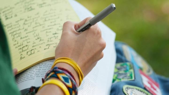 person writing on a notepad