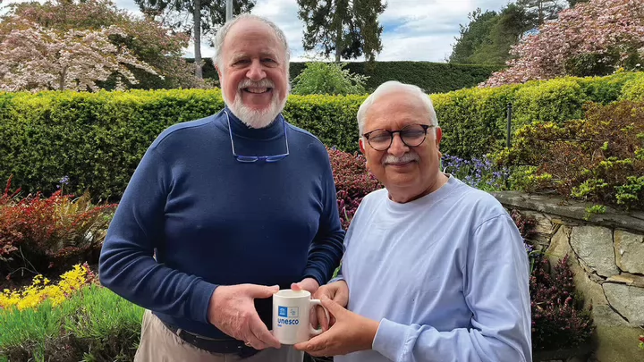 UNESCO Co-chairs of Community Based Research, Dr. Budd Hall and Dr. Rajesh Tandon, holding together a UNESCO branded mug
