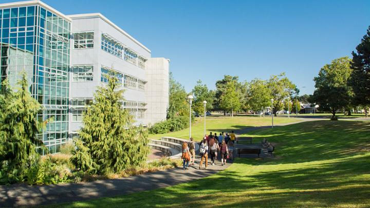 A group of students and employees walking on a path next to Mearns Centre at UVic campus