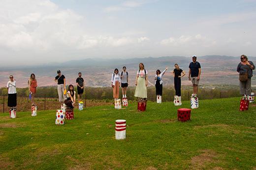 Field school participants pose on painted wooden stumps in a public park developed by Thai electricity company EGAT.