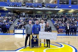 people stand on basketball court holding giant cheque