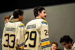 Two men in white jerseys with their backs facing the camera.