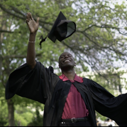 man throwing his grad hat in the air 