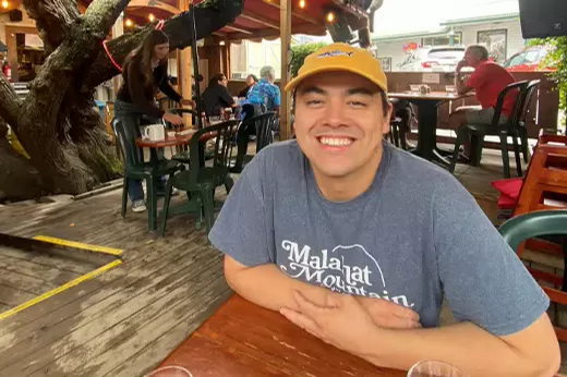 Jesse Dutnall sits at an outdoor table at a restaurant.