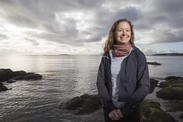 Natalie Ban stands by the ocean.
