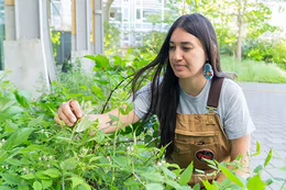 Loreisa Lepine with a Blackcap Raspberry bush, an Indigenous plant.