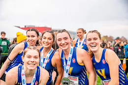 The women's cross country team poses with their bronze medals.