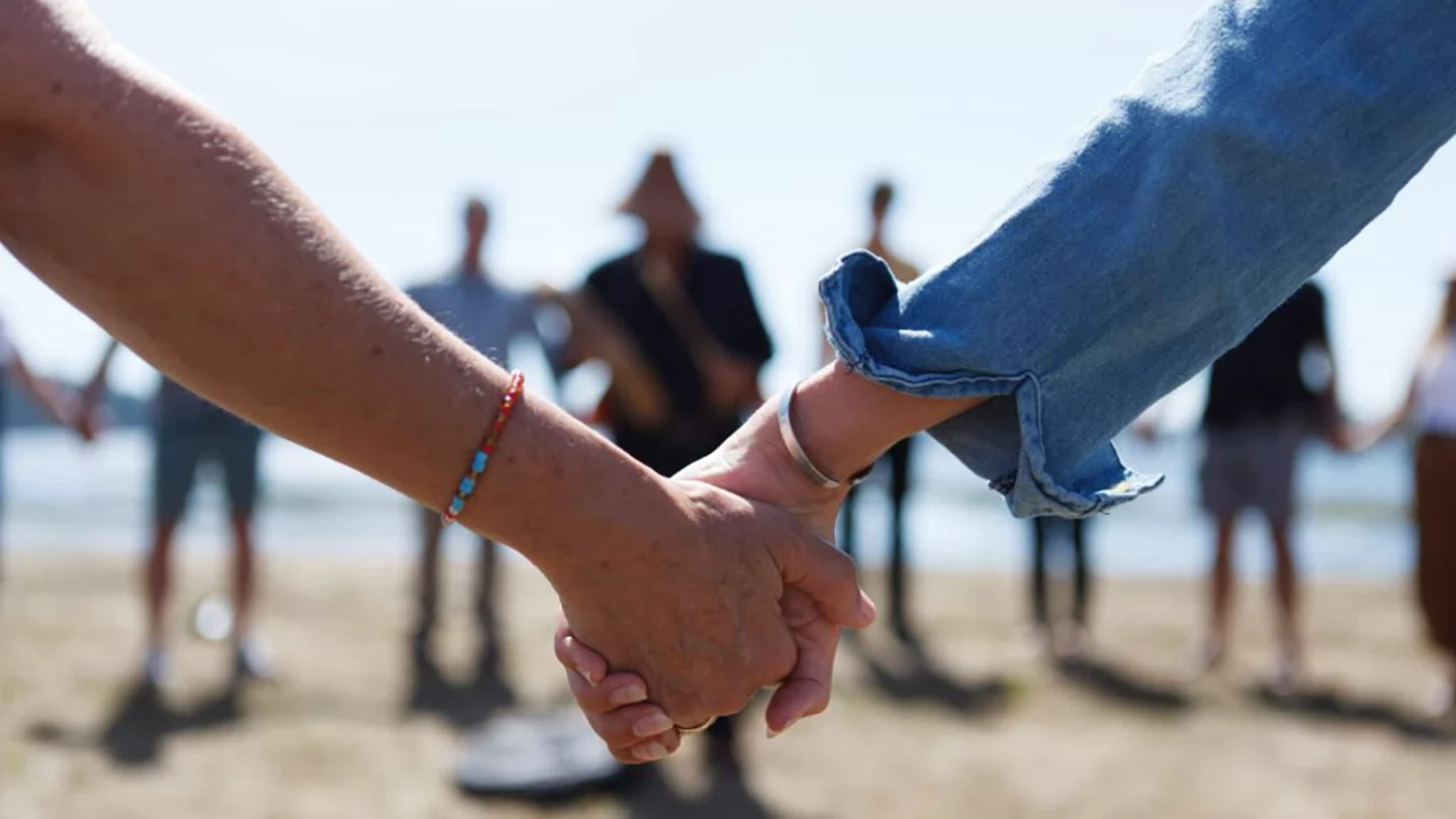 Close up shot of two arms holding hands