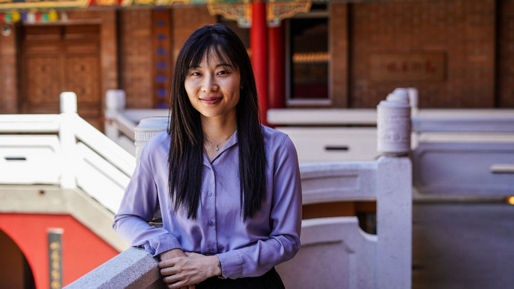 Person with a purple shirt standing in the courtyard of a buddhist centre