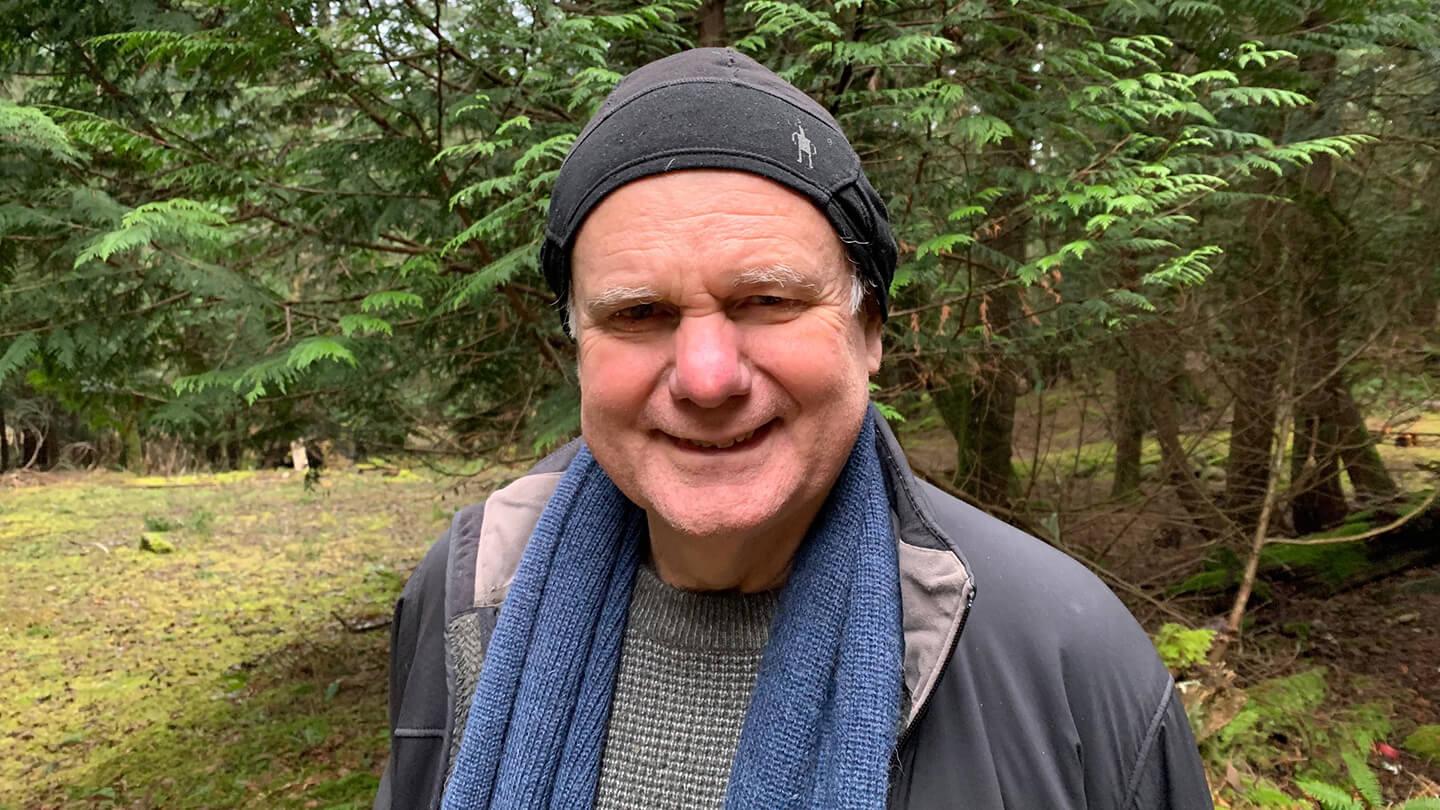 Michael Dunn smiling in the woods