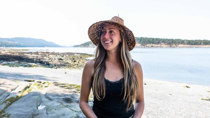 Artist Sarah Jim smiling on a beach.