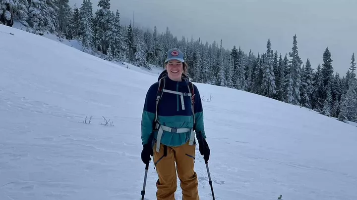Jessica on skis, snow-covered trees in background