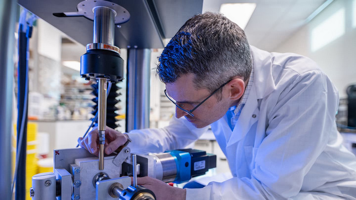 Dr. Josh Giles, Mechanical Engineering uses a machine in a lab