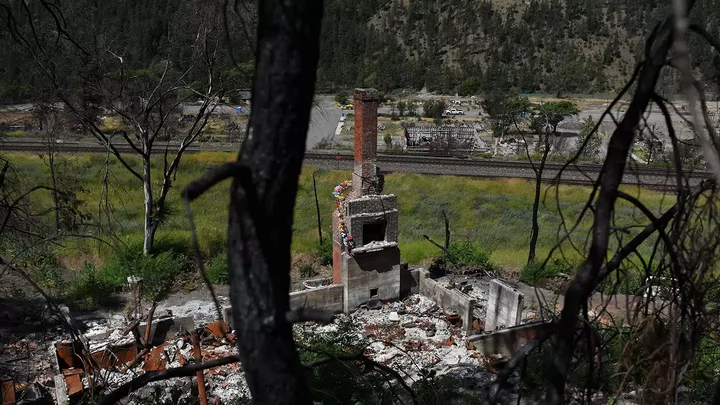 A single brick chimney stack among the ruins of a house