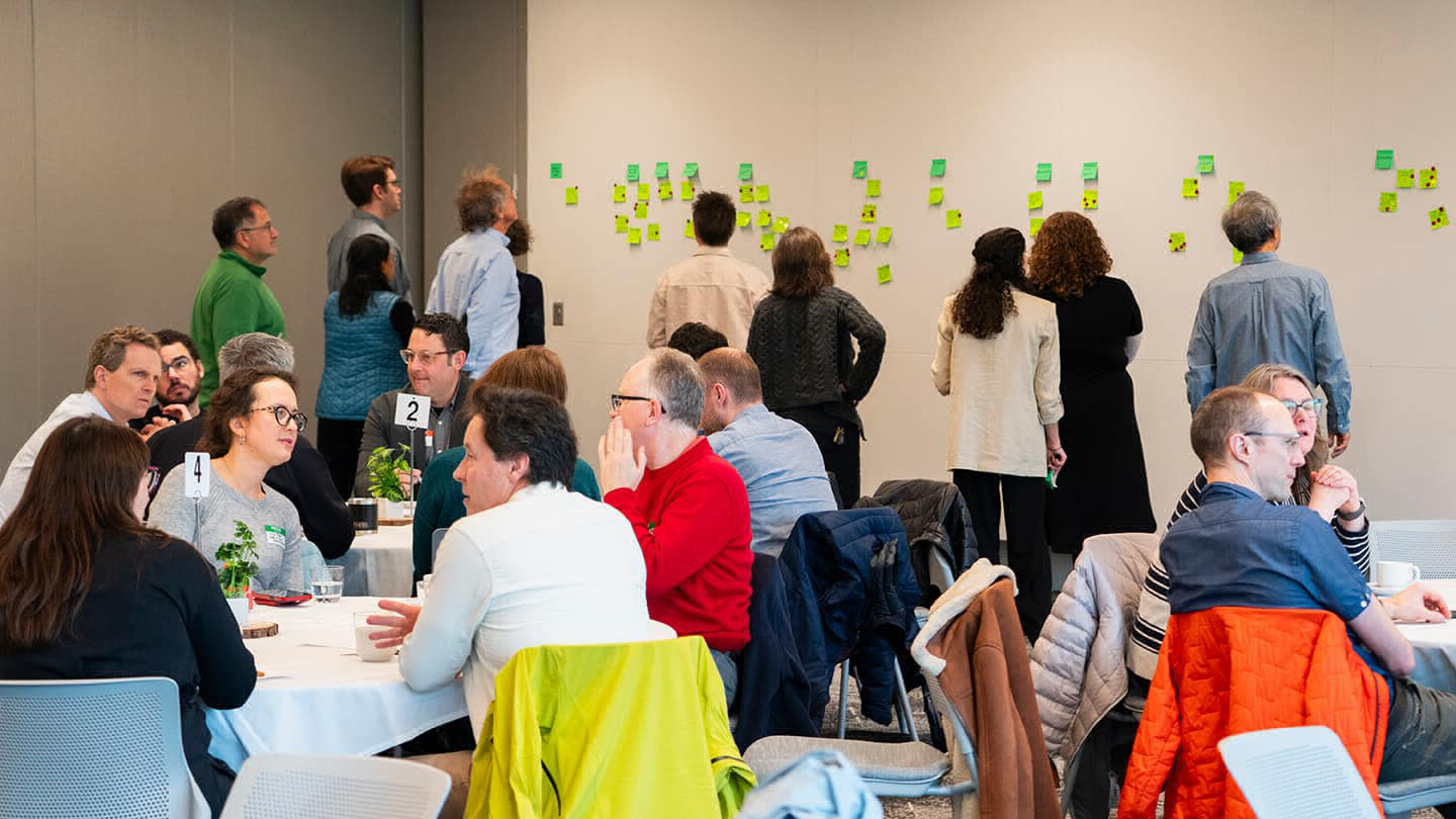 Researchers sit at round tables discussing climate action ideas over lunch