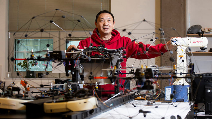 Yang Shi in his lab surrounded by drones and other tech