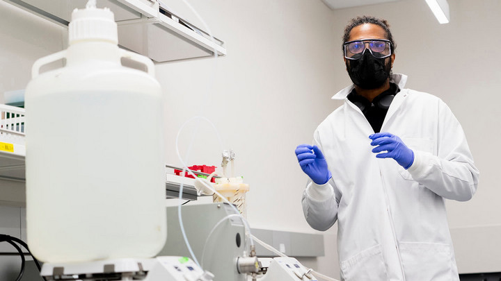 Post-doc Luiz H. Da Silva Correa stands in the Health Core lab wearing lab safety equipment