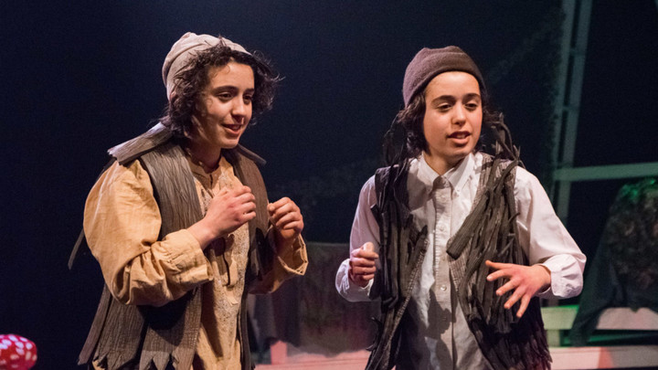 Twin actors on stage in costume performing in the play Peter Pan