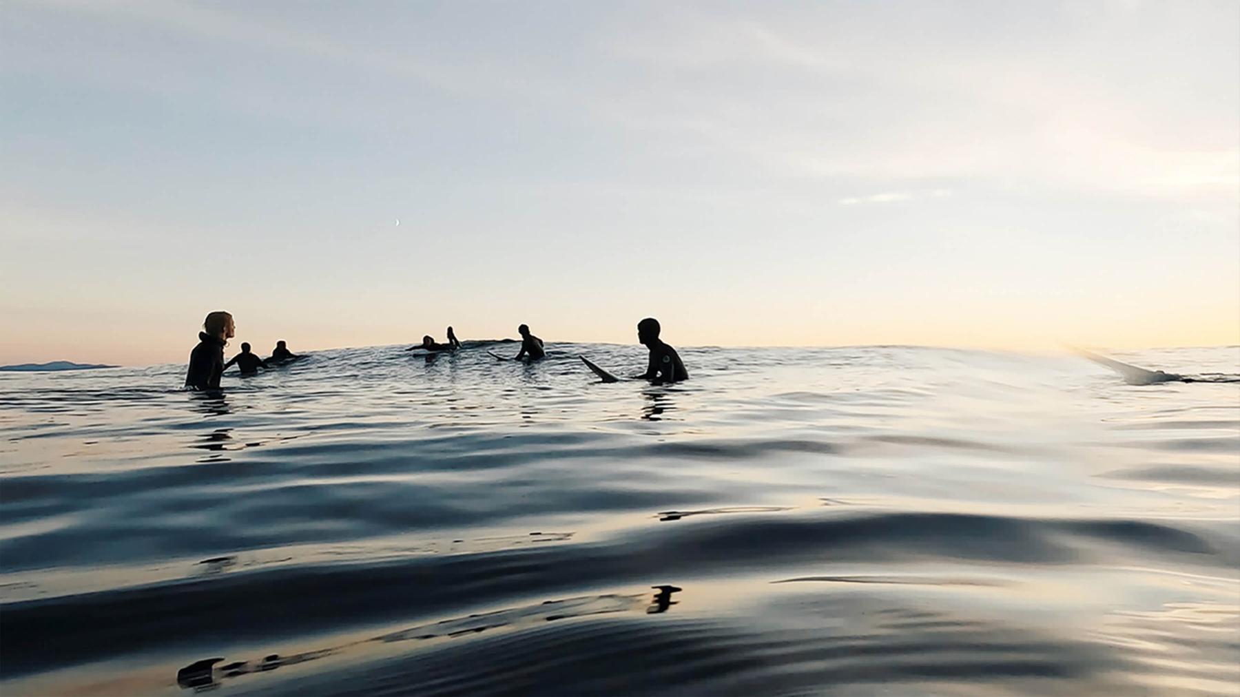 People floating on surfboards in the ocean,