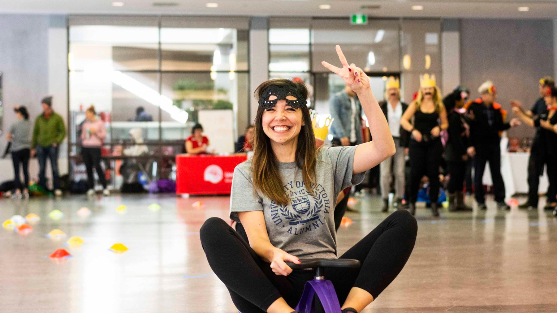 UVic staff member rides a purple plasma car in the Michele Pujol Room at the Student Union Building. They are taking part in the annual United Way plasma car race fundraiser..