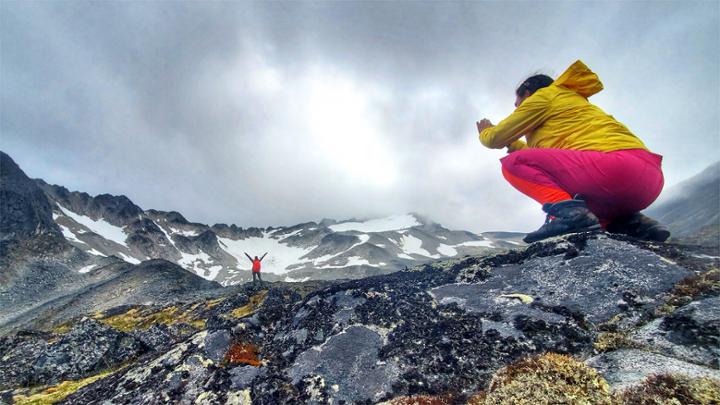 student taking picture of another student in the mountains