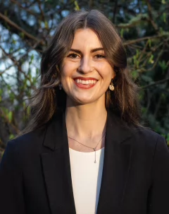 Profile picture of Chloe Johnston smiling to the camera with a forested background