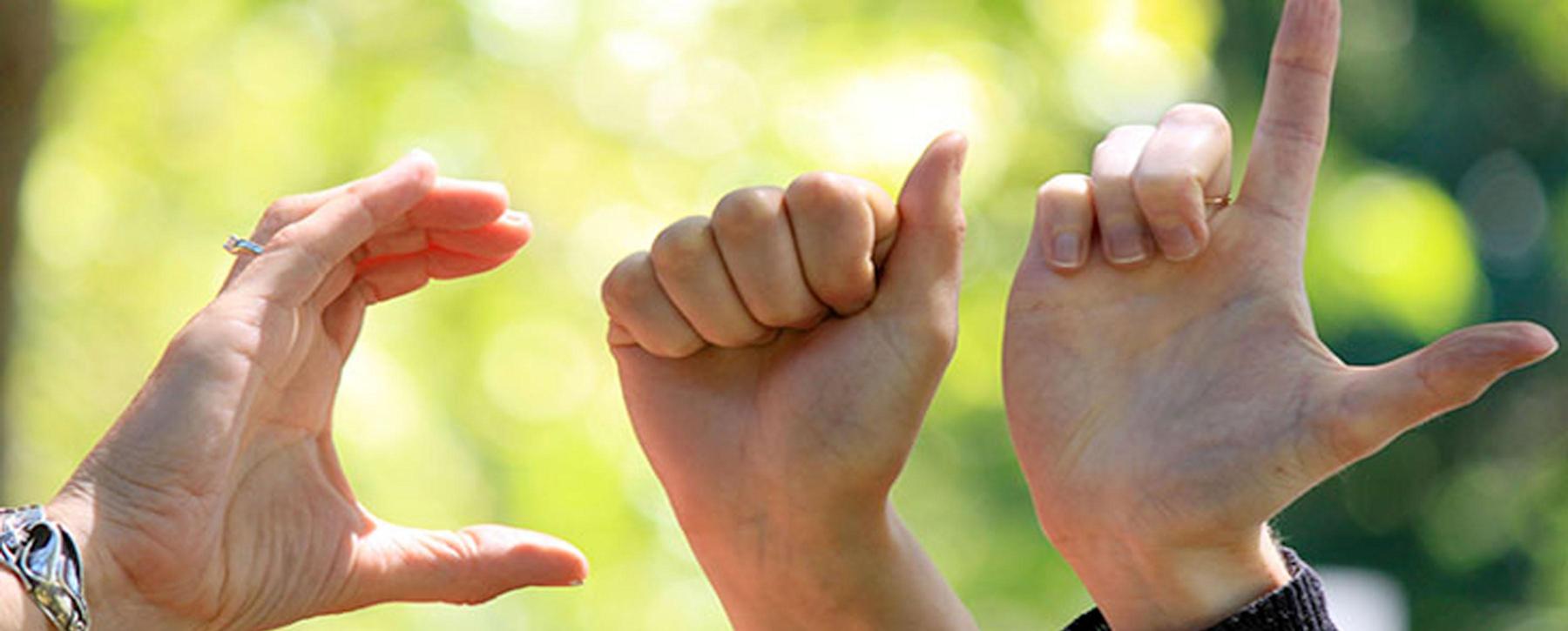 hands spelling out cal in sign language