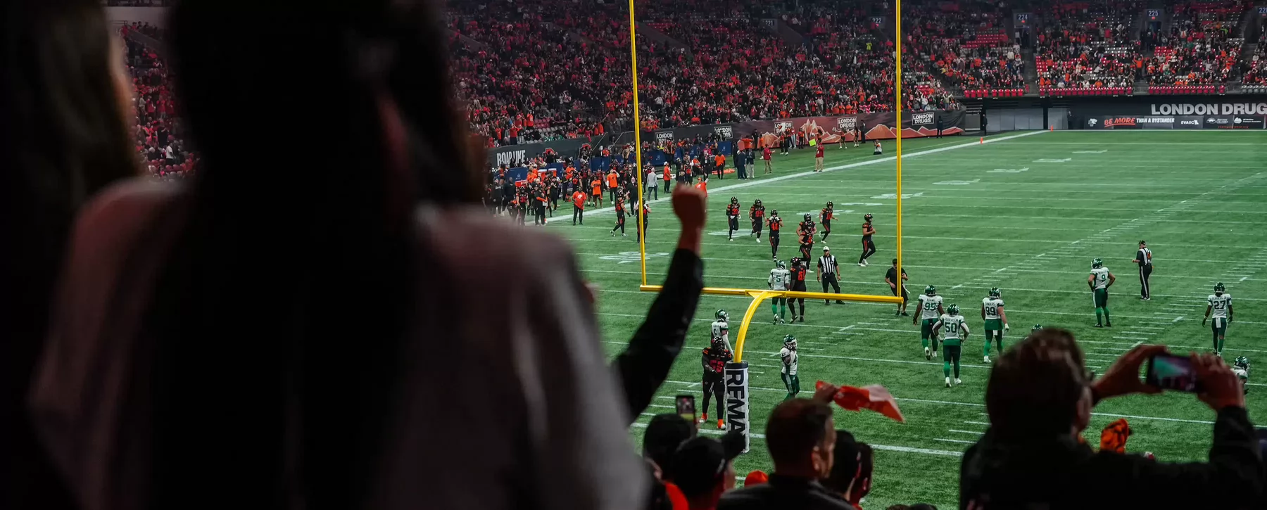 Fans cheering during a BC Lions football game.