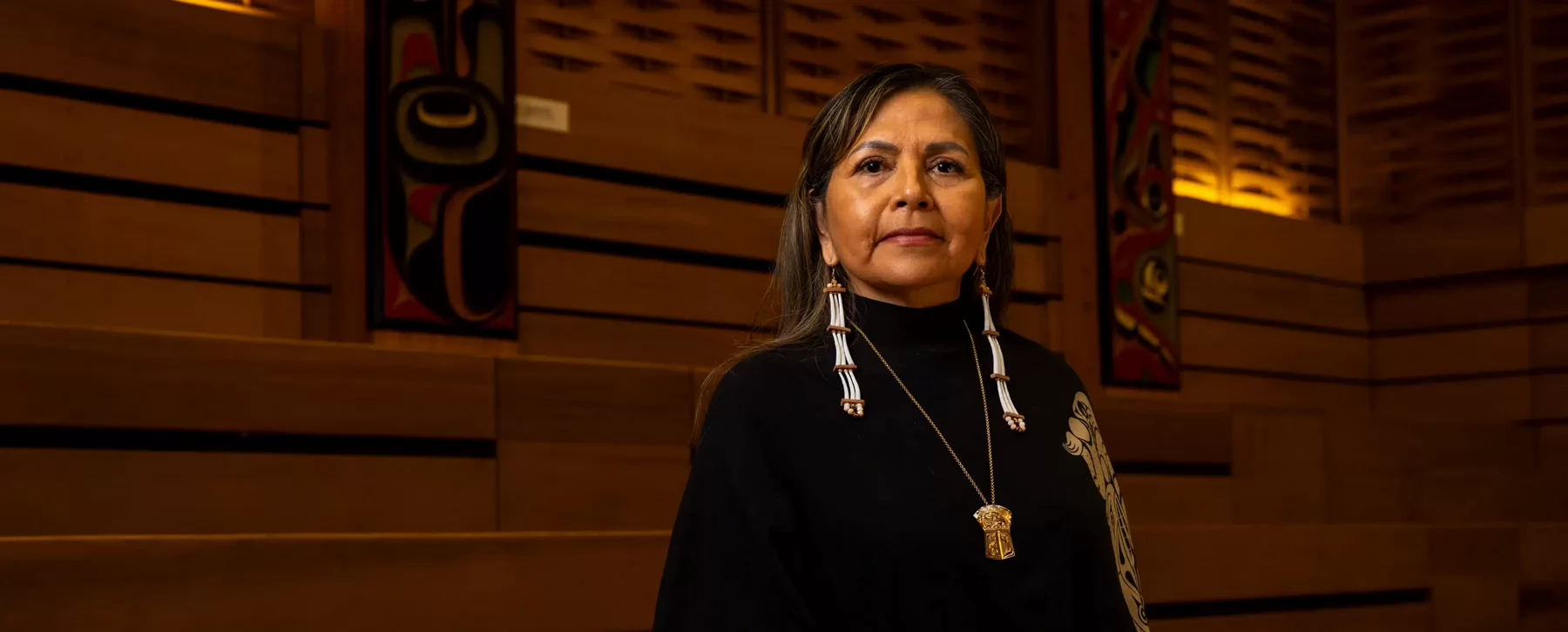 A woman wearing Indigenous earrings and necklace. 