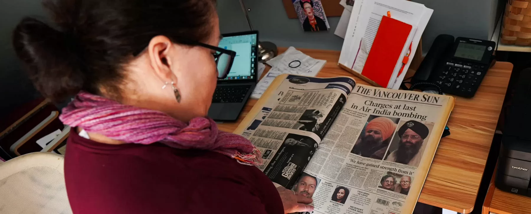 A woman looks at the front page of a the Vancouver Sun newspaper's front page, which reads Charges At Last in Air India Bombing.